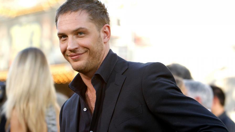 Улыбающийся актер Том Харди в костюме