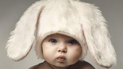 Ребенок в шапке кролика надул щеки скачать обои