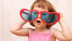 Смешная девочка в очках в виде сердечек